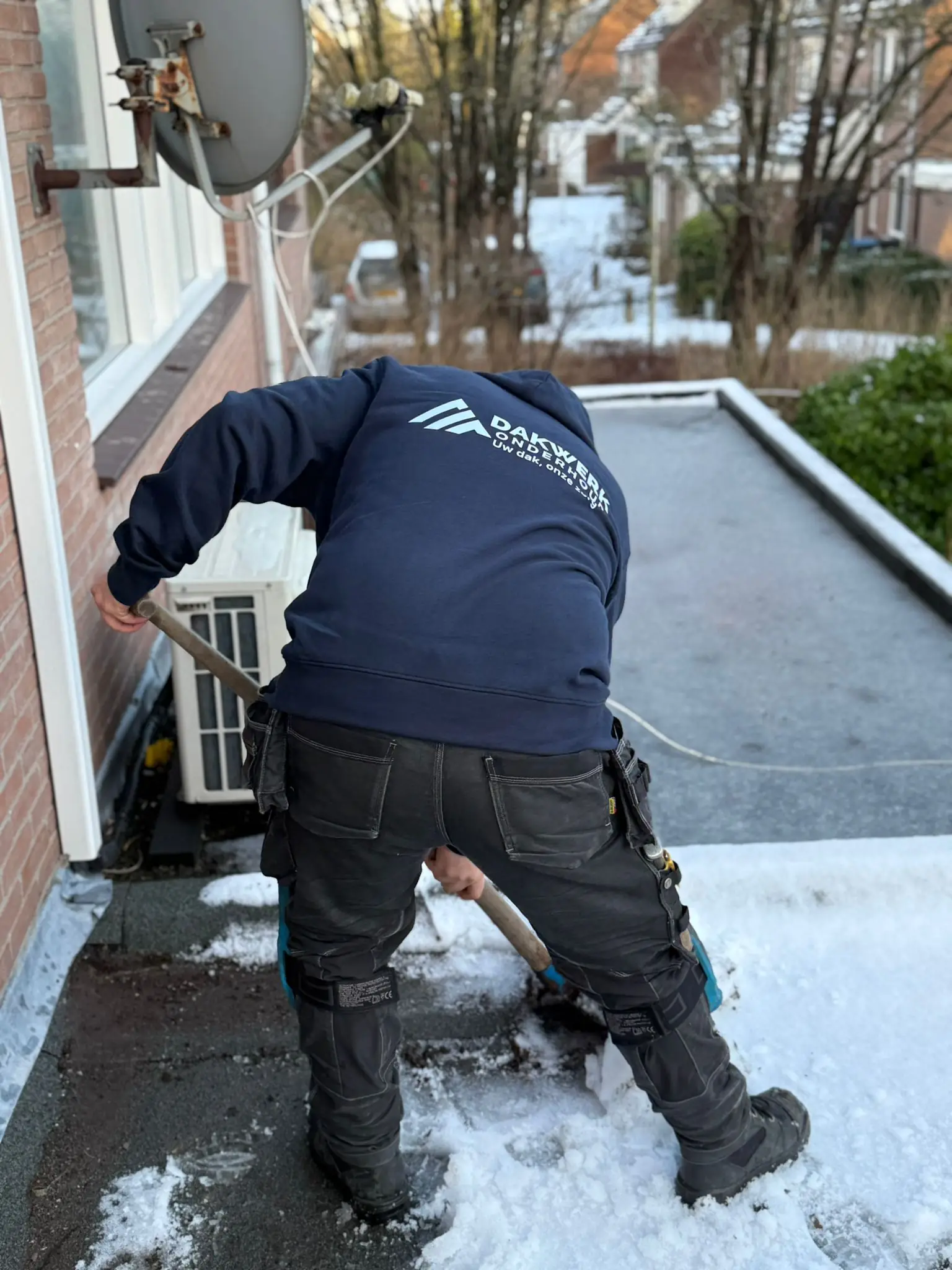 Professional roofer replacing storm-damaged tiles on Dutch roof